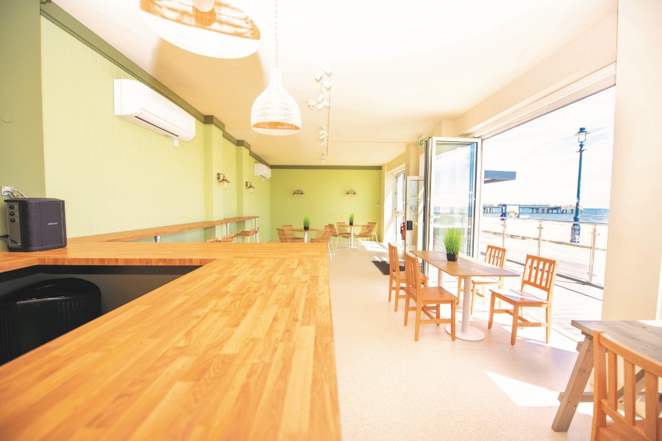 Interior view of the venue including tables, chairs and the kitchen area.